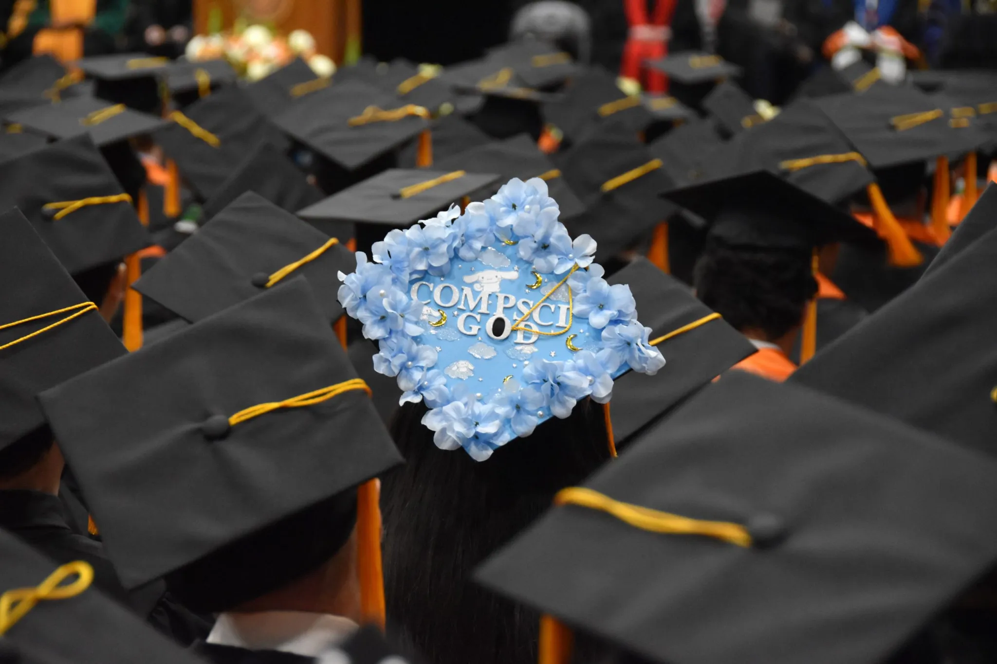 Graduating students with one decorated blue, floral cap